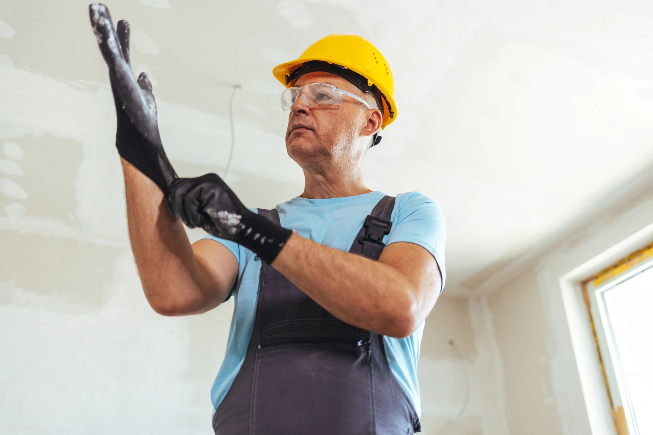 Worker putting on protective work gloves at a job site