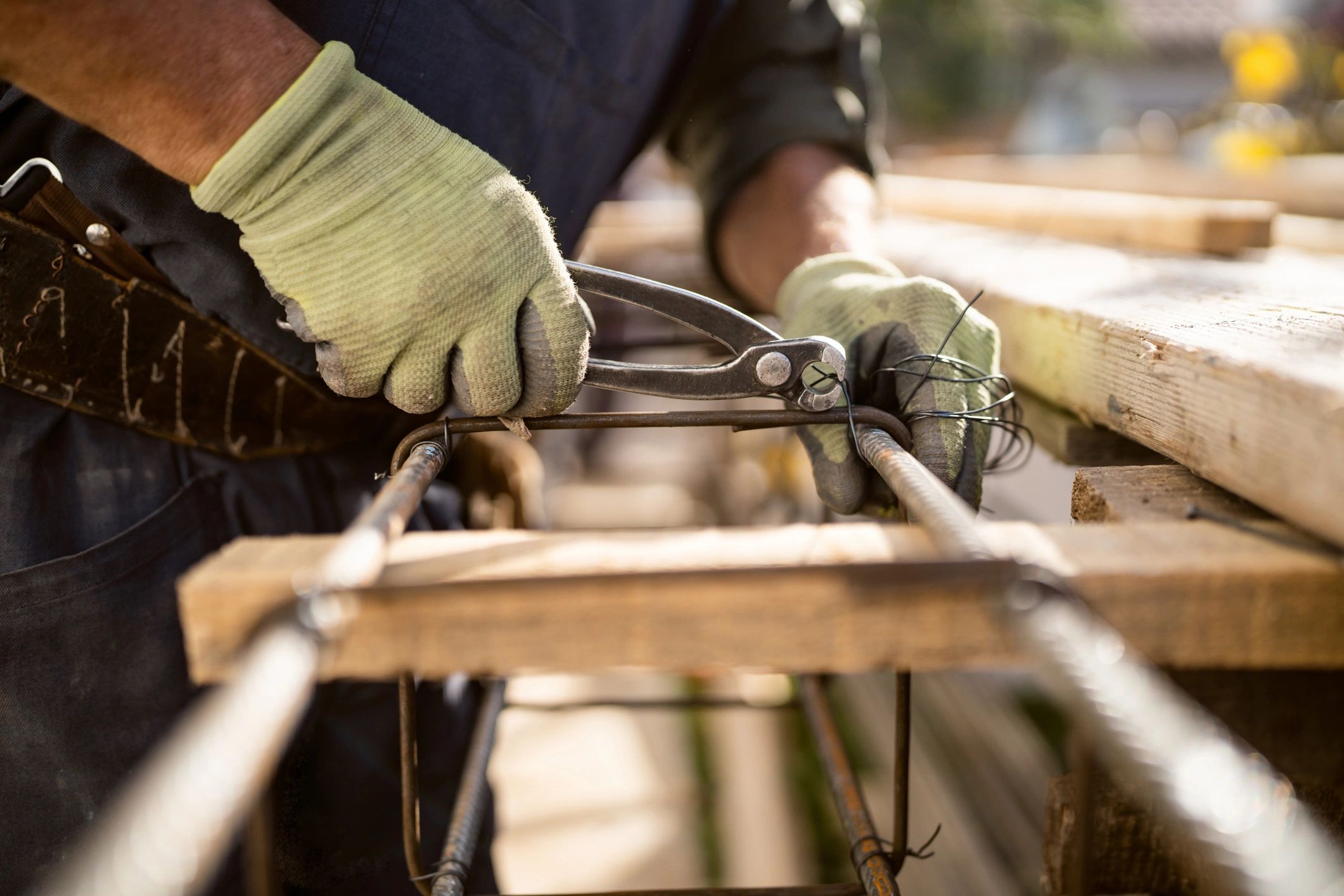 Construction worker using pliers while wearing work gloves