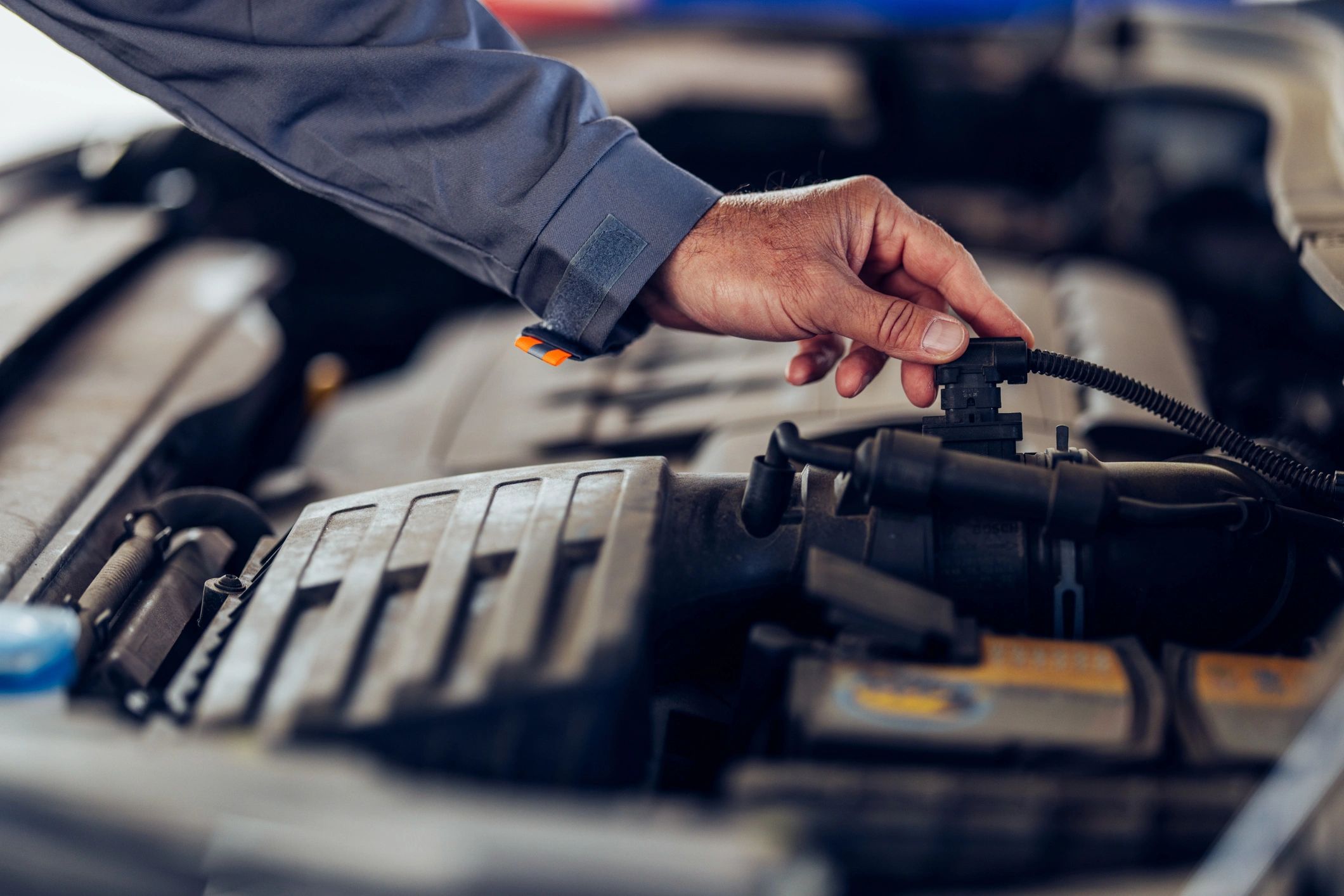 Mechanic hand working on an engine wearing gloves